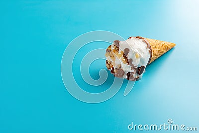 Mini Vanilla flavor ice cream cone starts melting on blue Stock Photo