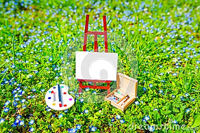 Miniature Artist's Set Placed Nestled in a Spring Field Stock Photo