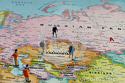 Miniature backpackers and miniature police standing on a map of the world. Stock Photo