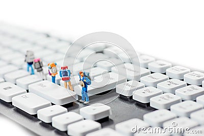 Miniature backpackers on top of the keyboard. Stock Photo