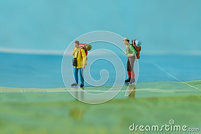 Miniature backpackers walking on map as background travel concept Stock Photo
