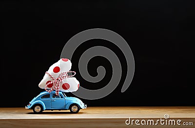 Miniature blue car carrying a red heart Stock Photo