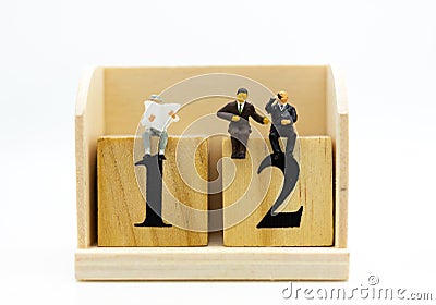 Miniature businessman sitting on number wooden block. Image use for business concept Stock Photo