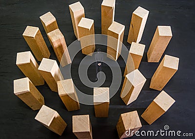 Miniature businessman stand in a circle of wooden blocks. Black background. Crisis and failure in Business, Insurance and Risk Man Stock Photo