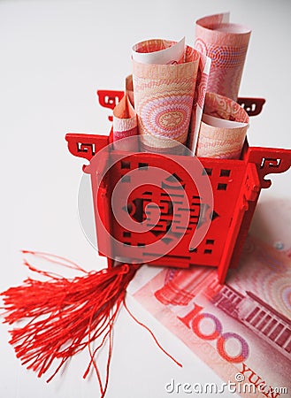 Miniature Chinese pavilion in bright red standing on and filled with Chinese 100 renminbi banknotes Stock Photo