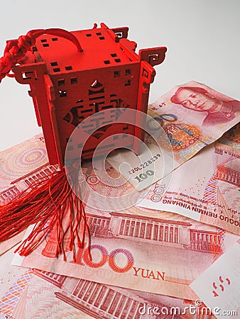 Miniature Chinese pavilion in bright red standing on Chinese 100 renminbi banknotes against a white background Stock Photo
