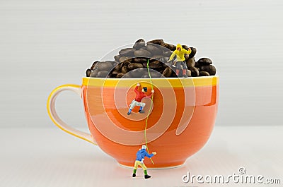 Miniature climbers climbing coffee cup Stock Photo