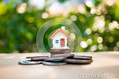 Miniature colorful house with stack coins on city background Stock Photo