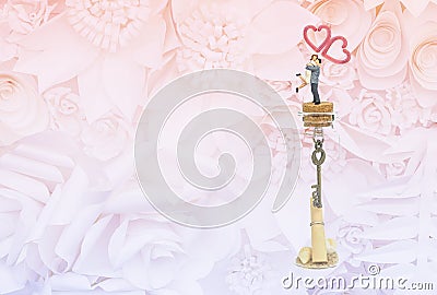 Miniature couple on message in the bottle on flower pattern background Stock Photo
