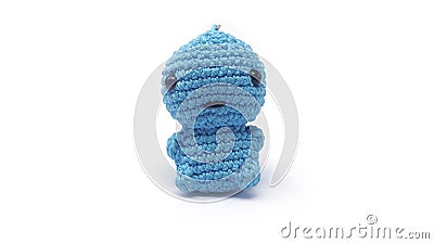 Miniature dino keychain in blue colors crocheted on a white background Stock Photo