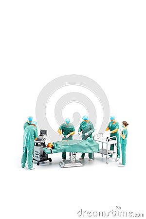 Miniature Doctor performing surgery on patient on white background Stock Photo