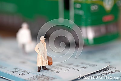 Miniature doll model standing on the train ticket Stock Photo