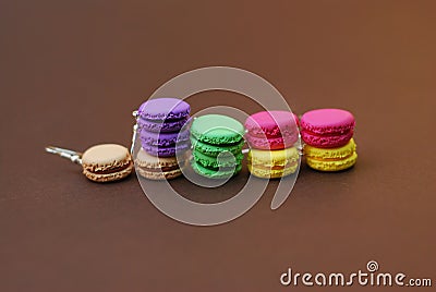 Miniature Fake Macaroons on Brown Background. Earrings made from Polymer Clay. Plastic dummies. Symbol of French Sweets Dessert. C Stock Photo