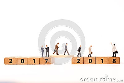 Miniature figure businessman walking on number wooden block across from 2017 to 2018 Stock Photo