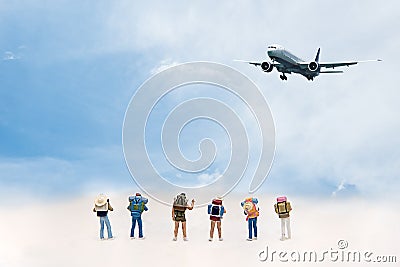 Miniature Group hiker and traveler with backpack standing and walking to airplane blue sky background, Stock Photo