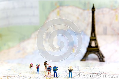 Miniature Group hiker and traveler backpack standing on wold map for travel Eiffel Tower in France and around the world, Stock Photo