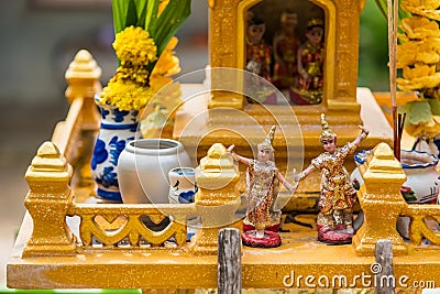 Miniature guardian spirit house. Small buddhist temple shrine, colorful flower garlands. San phra phum erected to bring fortune. Stock Photo