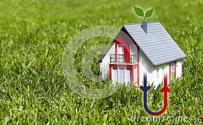 Miniature house in the grass with geothermal heat or heating Stock Photo