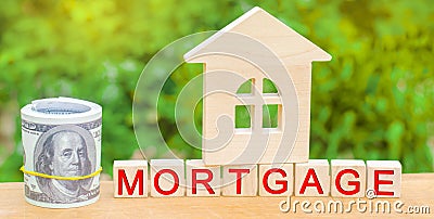 Miniature house and money. Wooden blocks and the inscription `mortgage`. credit for property / apartment. Business loans for real Stock Photo