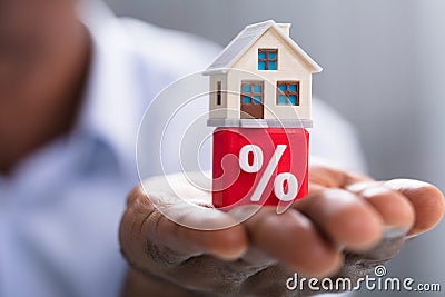 Miniature House On Percentage Block Over The Hand Stock Photo