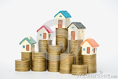 Miniature house on stack coins using as property and business concep, isolated on white background Stock Photo