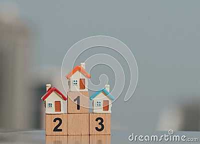 Miniature houses on wooden block number one two three using as business and property concept. Stock Photo