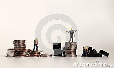 Miniature manual workers with coins. Stock Photo