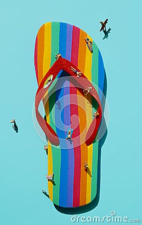 Miniature men on a rainbow-patterned flip-flop Stock Photo