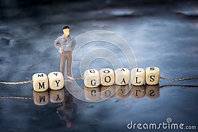 Miniature model of man and wooden cubes with my goals inscription strung on a thread Stock Photo