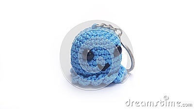 Miniature octopus keychain in blue colors crocheted on a white background Stock Photo