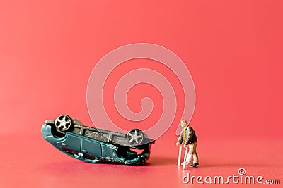 Miniature people broken leg man patient with bandage walking with crutch with toy car wreck Stock Photo