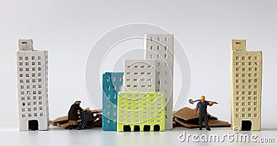 Miniature people between miniature buildings. Stock Photo