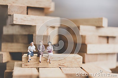 Miniature people : Business People sitting on wood block Stock Photo