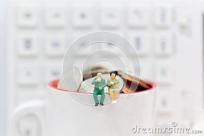 Miniature people : Business sitting on the glass and having a coffee break. Image use for food and beverage business concept Stock Photo