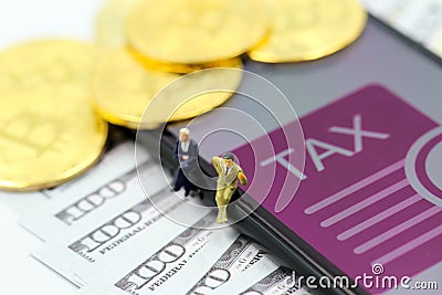 Miniature people : businessman Bitcoin Crypto Currency with TAX message and dollars money ,Determining the tax law of digital Stock Photo