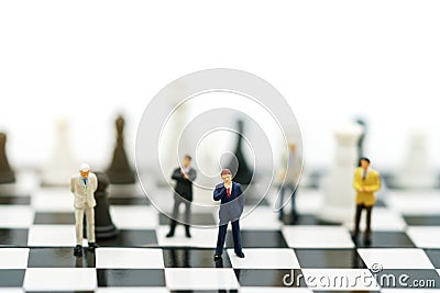 Miniature people: Businessman handshake to business success on chessboard. Commitment, agreement, investment and partnership Stock Photo