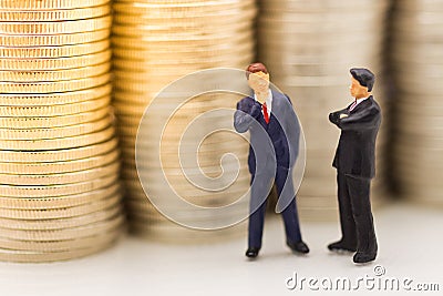 Miniature people, Businessman looking for stack of coins using as background money growth up, saving, financial, business concept Stock Photo