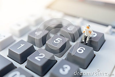 Miniature people: Businessman reading on calculator. Financial and business concept. Stock Photo