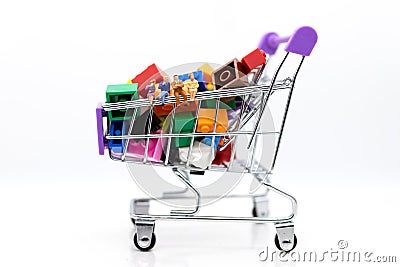 Miniature people: Businessman setting with shopping cart. Image use for shopping, marketing place world wide, business concept. Stock Photo