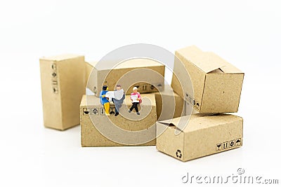 Miniature people : Businessman sitting on box in warehouse. Image use for business, industrial and logistic concept Stock Photo