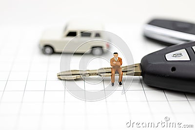 Miniature people : Businessman sitting on car key. Image use for Advertising product in the market today, competition on the Stock Photo