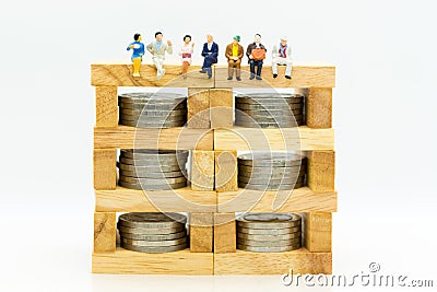 Miniature people: Businessman sitting on a wooden block to keep money bank. Image use for business concept Stock Photo