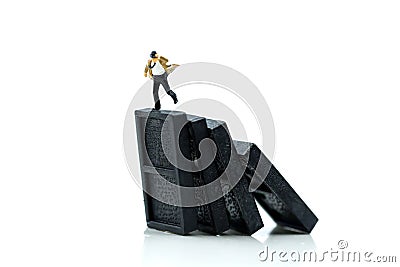 Miniature people : Businessman with Stack of dominoes falling ,business solution, strategy and successful intervention Stock Photo
