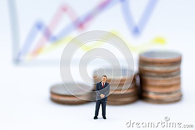 Miniature people: Businessman stand front of dashboard, display graphs, profit margins of background. Image use for business Stock Photo