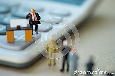 Miniature people businessman standing on calculator and talk to staff about salary and wage increase Stock Photo