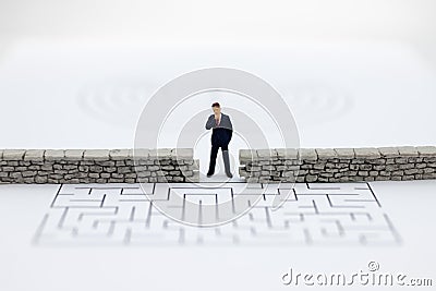 Miniature people: Businessman standing front of the wall and the world is inside. Image use for business security center, protect. Stock Photo