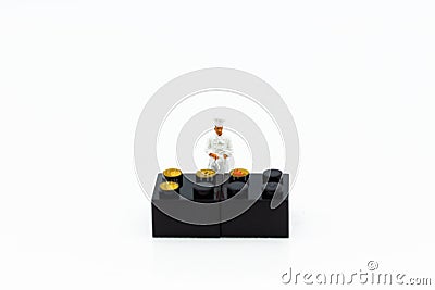 Miniature people: Chef is making dessert on the stove grill. Image use for food and beverage concept Stock Photo