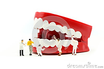 Miniature people : clean tooth or dental model with Dentist examining a patient`s teeth ,using for concept of Dentist`s Day Stock Photo