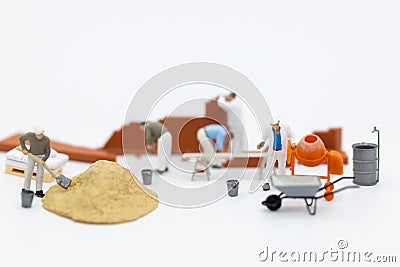 Miniature people: Construction workers building plans , have building materials, sand, brick, mortar. Use image for construction Stock Photo