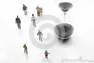 Miniature people. different people are walking next to the hourglass on a white background. lifespan of humanity Stock Photo